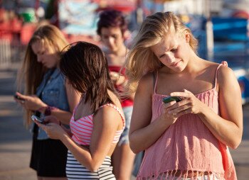 Young people staring at smartphones